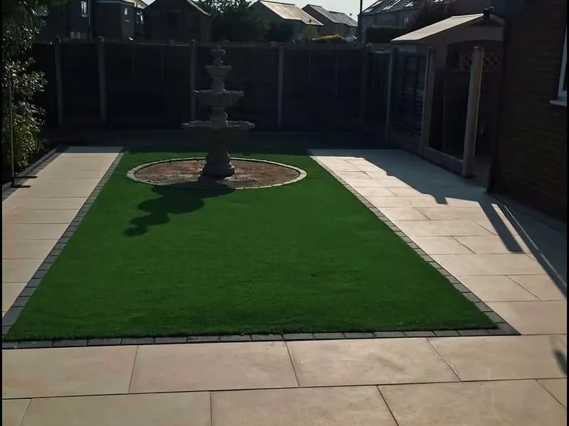 Back garden with artificial lawn, a central water feature and a porcelain surround