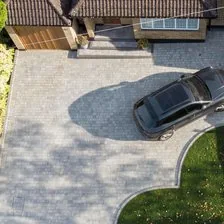 Block paved driveway seen from above, with a car parked on it