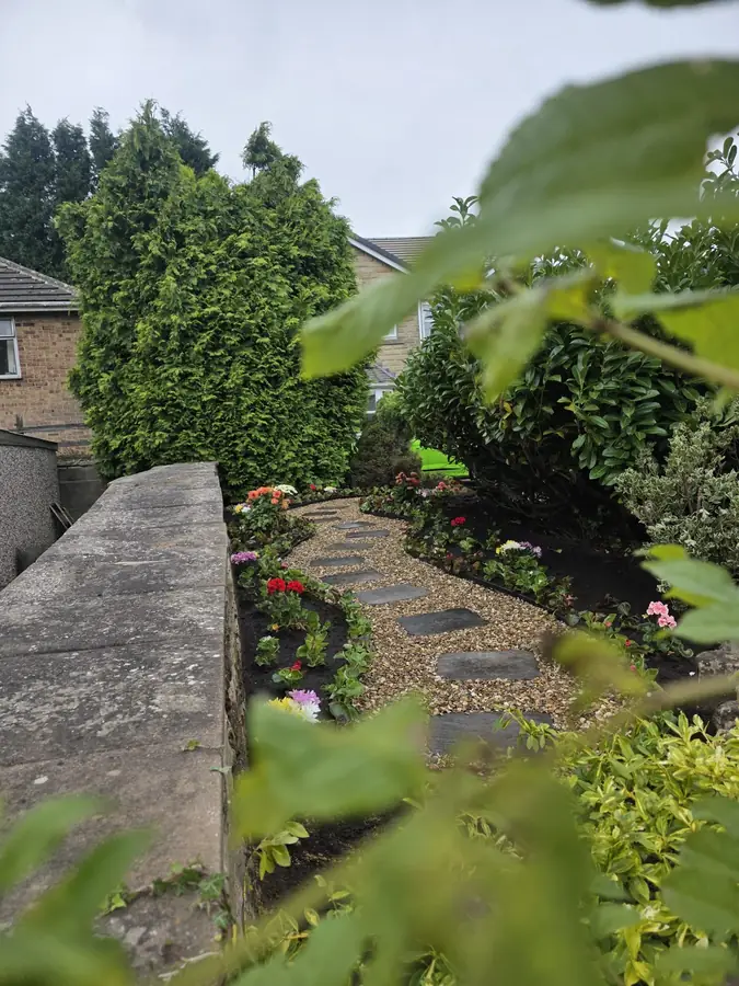 The finished gravel path and its planting seen from above, over a stone wall