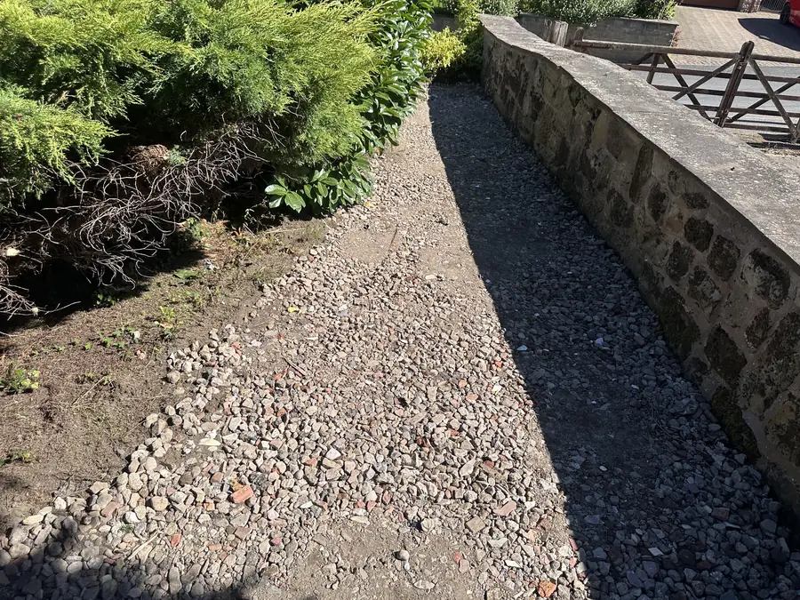 The side strip dug out, with a compacted stone base and edging running along it